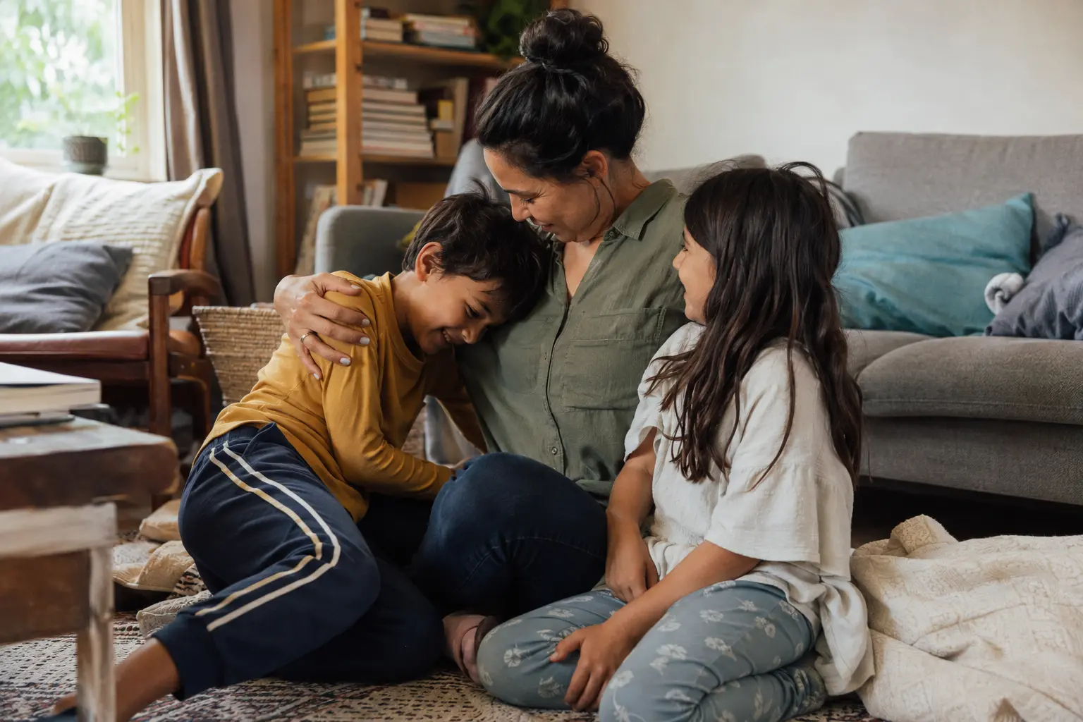 A parent and two children sharing a relaxed moment together at home